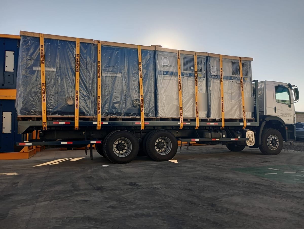 Tortón de plataforma de RHT con equipo industrial embalado en plástico y sujetado con cinchos de carga